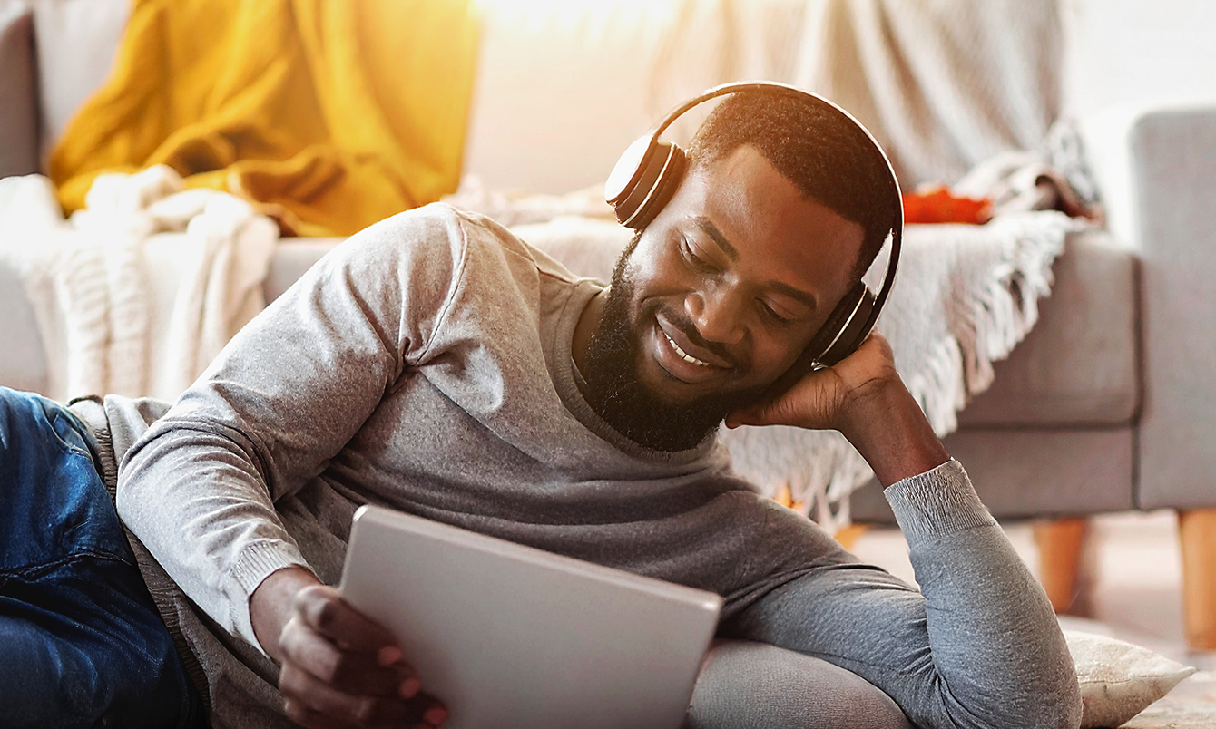 Man listening to music while using a laptop powered by OptimumInternet